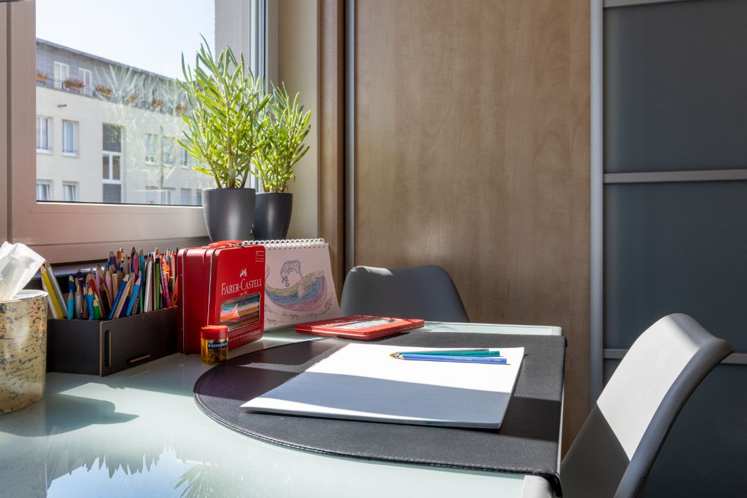 Arbeitstisch mit Papier und Buntstiften in der Praxis
